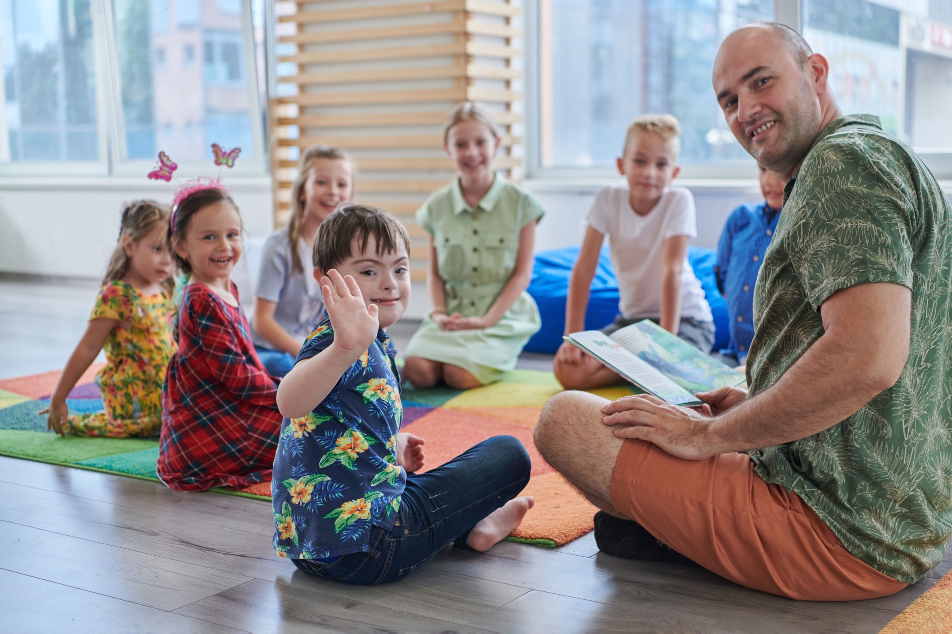 Reading time in an elementary school or kindergarten, a teacher reading a book to children in an elementary school or kindergarten. The concept of pre-school education. Selective focus