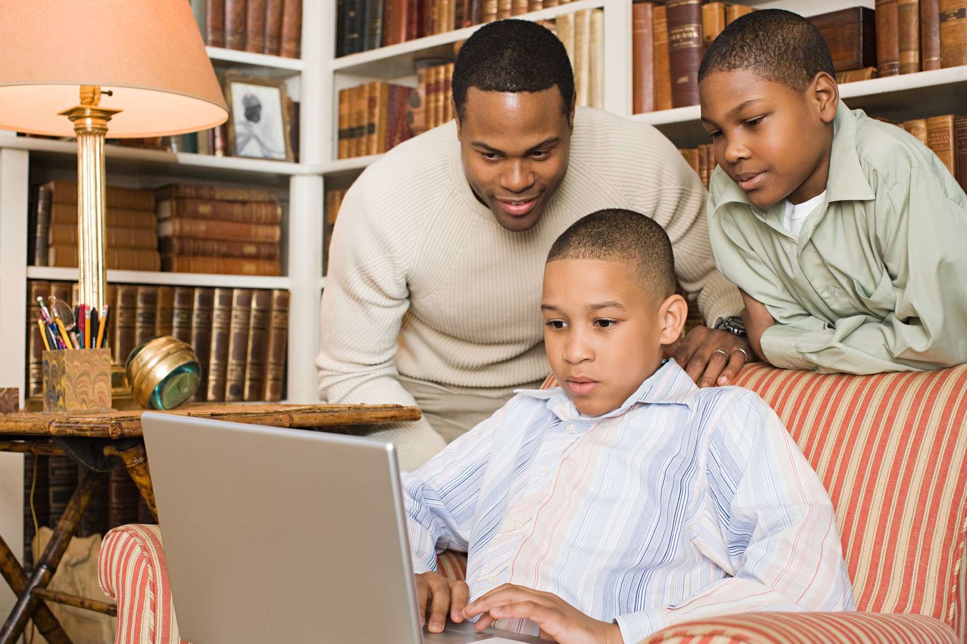 Father and sons looking at laptop