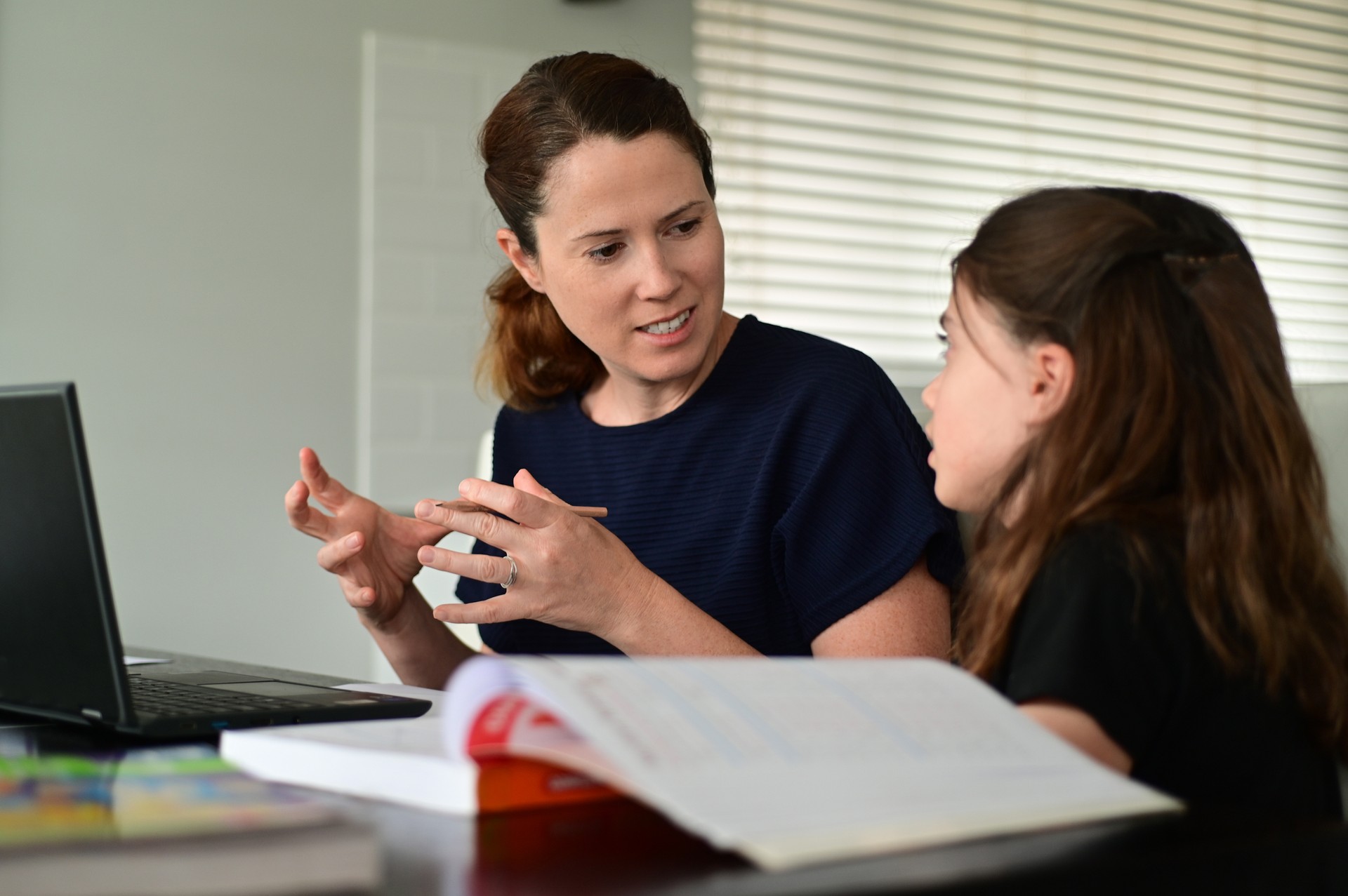 Mother homeschooling her young daughter